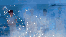 a group of people are standing in front of a body of water