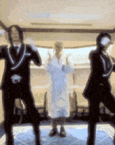 a man in a robe is dancing with two other men