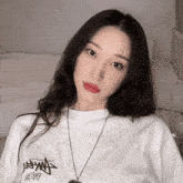 a woman wearing a stussy t-shirt and a necklace