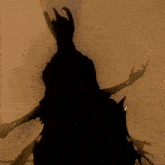 a silhouette of a demon with horns holding a sword