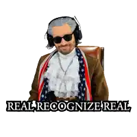 a man wearing headphones and a scarf with the words " real recognize real " on the bottom