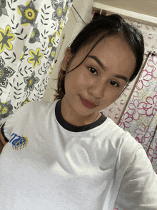 a woman taking a selfie in front of a shower curtain with yellow flowers