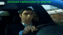a man is driving a car with the words rüzgar yapacagin isi sikeyim written above him