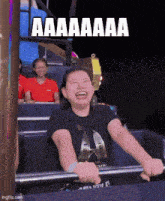 a woman is laughing while riding a roller coaster with the words " aaa " written on the screen