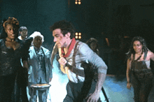 a group of people are standing on a stage with smoke coming out of them .