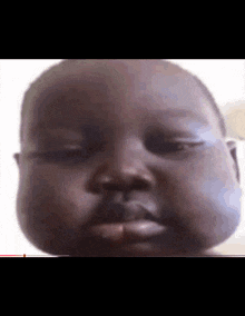 a close up of a baby making a funny face