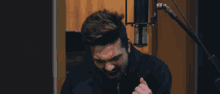 a man singing into a microphone with his fist up