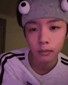 a young man wearing a headband with big eyes