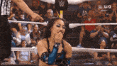 a woman in a wrestling ring with a sign that says ua on it