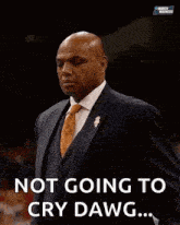 a man in a suit holds his hands to his chest with the words not going to cry dawg below him