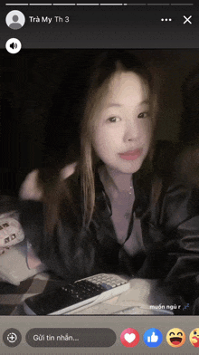 a woman laying on a bed with a phone and a remote control in front of her face