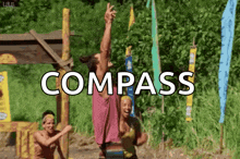 a group of people are playing a game with the word compass in the background .