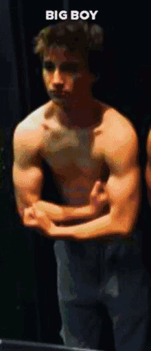 a shirtless man flexes his muscles in front of a mirror with the words big boy below him