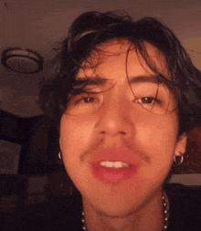 a close up of a young man 's face with a nose ring