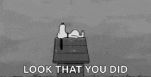 a black and white cartoon of snoopy laying on top of a wooden box in the rain .