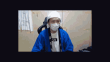 a man wearing a white mask and a blue jacket has a t-shirt that says ' i am '
