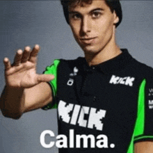 a man wearing a black and green shirt that says kick calma