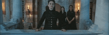 a woman in a black dress is standing in front of a group of women