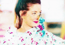 a woman is covered in confetti and looks at the camera .