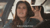 a woman is sitting in the back seat of a car and says " my life is a fucking shit show "