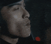 a close up of a man 's face with a green light in the background