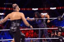 two women are wrestling in a ring with the word raw on the walls behind them