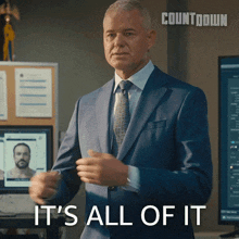 a man in a suit says it 's all of it in front of a computer