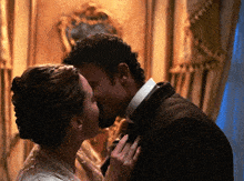 a man and a woman are kissing in front of a mirror .