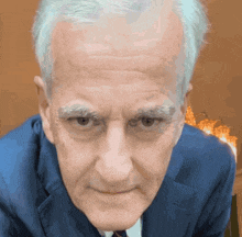a close up of a man 's face with gray hair