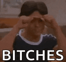 a woman is making a funny face and covering her eyes with her hands and the words `` bitches '' .
