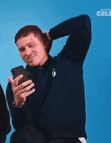 a man is looking at his phone with buzzfeed celebs written in the corner