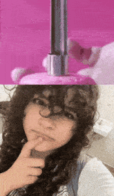 a girl with curly hair is taking a selfie with a pink background