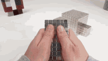 a person is playing with a stack of magnets on a table