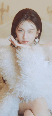 a woman wearing a white fur coat is winking at the camera