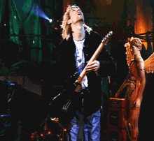 a man playing a guitar with a statue in the background