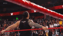a man in a wrestling ring with a sign that says raw on it