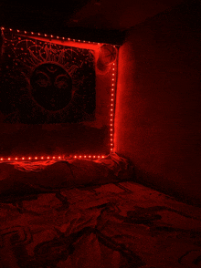 a bed in a dark room with red lights and a tapestry with the sun on it