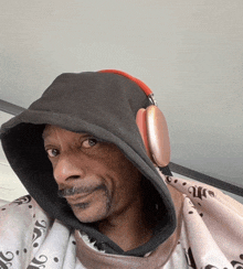 a man wearing headphones and a hooded sweatshirt with the letter j on it
