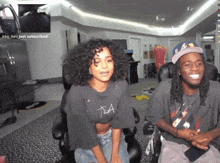a man and a woman are sitting next to each other and the woman is wearing a t-la shirt