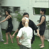 a group of people are standing on a lush green lawn with the hashtag colaishkinz