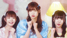 three girls are posing for a picture and one of them has a yellow lamp on her head