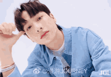 a young man in a blue denim jacket with the word journey on the bottom right