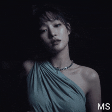 a woman in a gray dress with the word ms on the bottom right