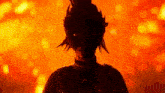 a person with a mask on their face is standing in front of a fire .