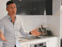 a man standing in a kitchen with a book on the counter that says ' healthy living ' on it