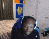 a man wearing headphones is sitting in a bedroom