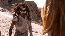 a woman is standing next to a man wrapped in a blanket