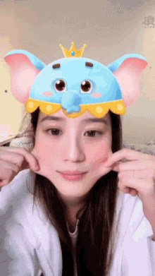 a woman wearing a blue elephant mask with a crown