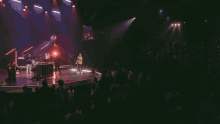 a woman singing into a microphone in front of a red light