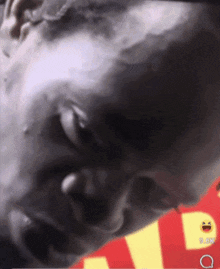 a close up of a man 's face with a yellow smiley face on the bottom right